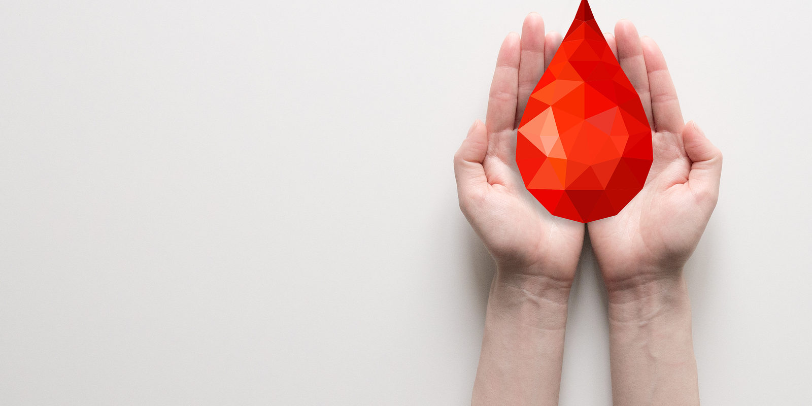 Due mani aperte che sostengono una grande goccia rossa stilizzata a mosaico, simbolo del dono del sangue Due mani aperte che sostengono una grande goccia rossa stilizzata a mosaico, simbolo del dono del sangue